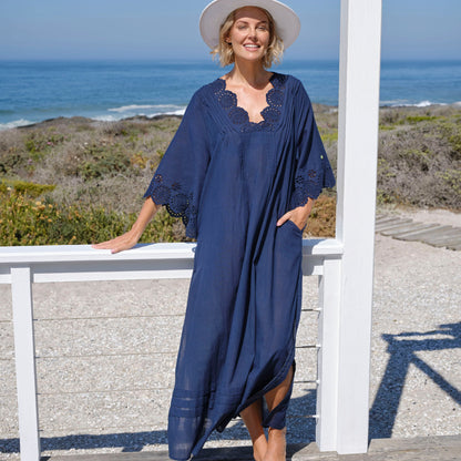 Woman in navy blue maxi kaftan with broderie detail at necline and sleeve edge